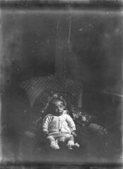 Bébé installé sur un coussin dans un fauteuil / [Anonyme].
