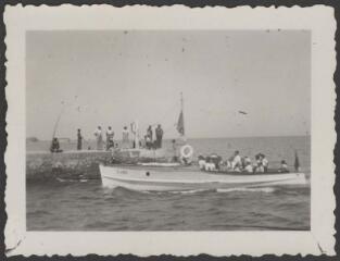 [Palavas, 1937]. Groupe de personnes rassemblées au bout d'un ponton sur la mer regardant l'arrivée d'une barque / LAMBERT (de), Louis.
