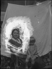 1 vue  - Portrait d\'un enfant devant une bâche blanche près du visage de sa mère. / [Anonyme] (ouvre la visionneuse)