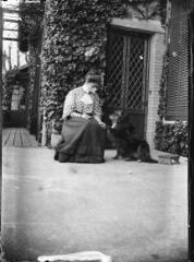 1 vue  - Portrait d\'une femme avec son chien devant la porte de sa maison. / [Anonyme] (ouvre la visionneuse)