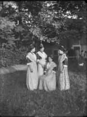 1 vue  - Quatre femmes en tenue traditionnelle d\'Arlésienne dans un jardin. / [Anonyme] (ouvre la visionneuse)