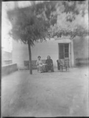 1 vue  - Deux femmes assises sur un banc devant une maison. / [Anonyme] (ouvre la visionneuse)