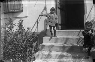 1 vue  - Deux enfants descendant des escaliers sur le perron d\'une maison. / [Anonyme] (ouvre la visionneuse)