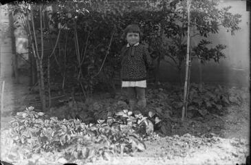 1 vue Enfant dans le jardin d'une maison. / [Anonyme]
