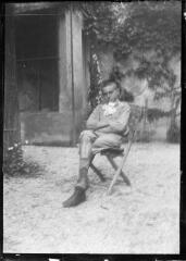 1 vue Jeune homme assis sur une chaise dans un jardin. / [Anonyme]