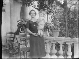 1 vue  - Femme avec son enfant sur la terrasse d\'une maison. / [Anonyme] (ouvre la visionneuse)