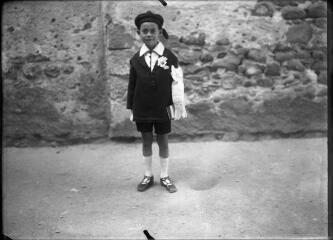 1 vue  - Portrait d\'un petit garçon en costume de communiant devant un mur de pierre. / [Anonyme] (ouvre la visionneuse)