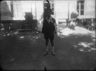 1 vue  - Portrait d\'un enfant en costume de communiant devant une maison. / [Anonyme] (ouvre la visionneuse)