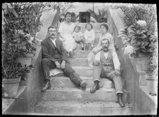 1 vue  - Famille assise sur les marches d\'un escalier de jardin. / [Anonyme] (ouvre la visionneuse)