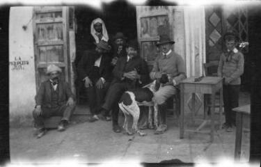 1 vue  - Groupe d\'hommes avec un chien devant un café. / [Anonyme] (ouvre la visionneuse)