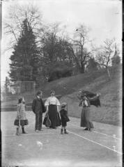 1 vue  - Femmes et enfants sur un terrain de jeu de tennis. / [Anonyme] (ouvre la visionneuse)