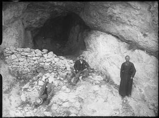 1 vue  - Deux hommes en canotier et un homme d\'église devant l\'entrée d\'une grotte dans la montagne. / [Anonyme] (ouvre la visionneuse)