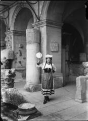 1 vue  - Portrait d\'une jeune femme en costume traditionnel, un tambourin à la main, à l\'intérieur du musée archéologique de Nîmes. / [Anonyme] (ouvre la visionneuse)