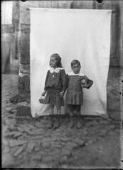 1 vue Portrait d' une petite fille avec un panier et d'un petit garçon avec un ballon devant un fond blanc. / [SAUNAL, Léon (photographe)]