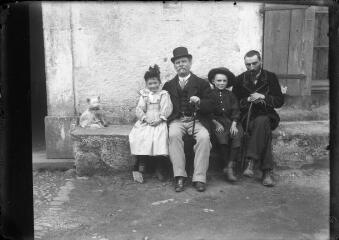 1 vue Portrait de groupe composé de deux hommes, deux enfants et un chien devant la façade extérieure d'une maison. / [SAUNAL, Léon (photographe)]