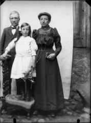 1 vue  - Portrait de la famille Tailhades (de Calas) : couple derrière une petite fille debout sur une chaise un bouquet de fleurs à la main. / [SAUNAL, Léon (photographe)] (ouvre la visionneuse)