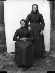 1 vue Portrait de deux femmes âgées l'une assise et l'autre appuyée debout derrière elle, devant une bâche blanche. / [SAUNAL, Léon (photographe)]