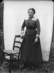 1 vue Portrait de femme appuyée à une chaise, devant une bâche blanche. / [SAUNAL, Léon (photographe)]