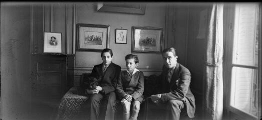1 vue Trois jeunes hommes assis sur un lit avec un chien. / [Famille SOULAS (photographe) (?)]