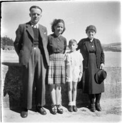 1 vue Famille de quatre personnes devant un muret. / [SAUNAL, Léon (photographe)]